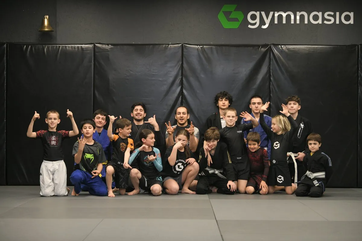 The Gymnasia kids BJJ class with their coaches on the mat in Tbilisi